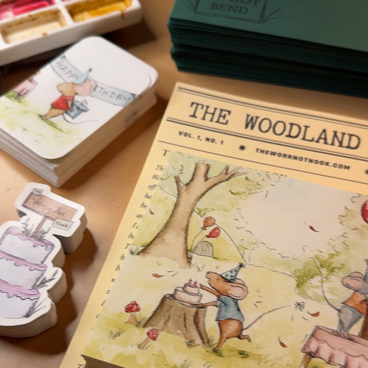 Woodland illustrations of animals and a storybook letter/story titled 'The Woodland Post' on a wooden surface.